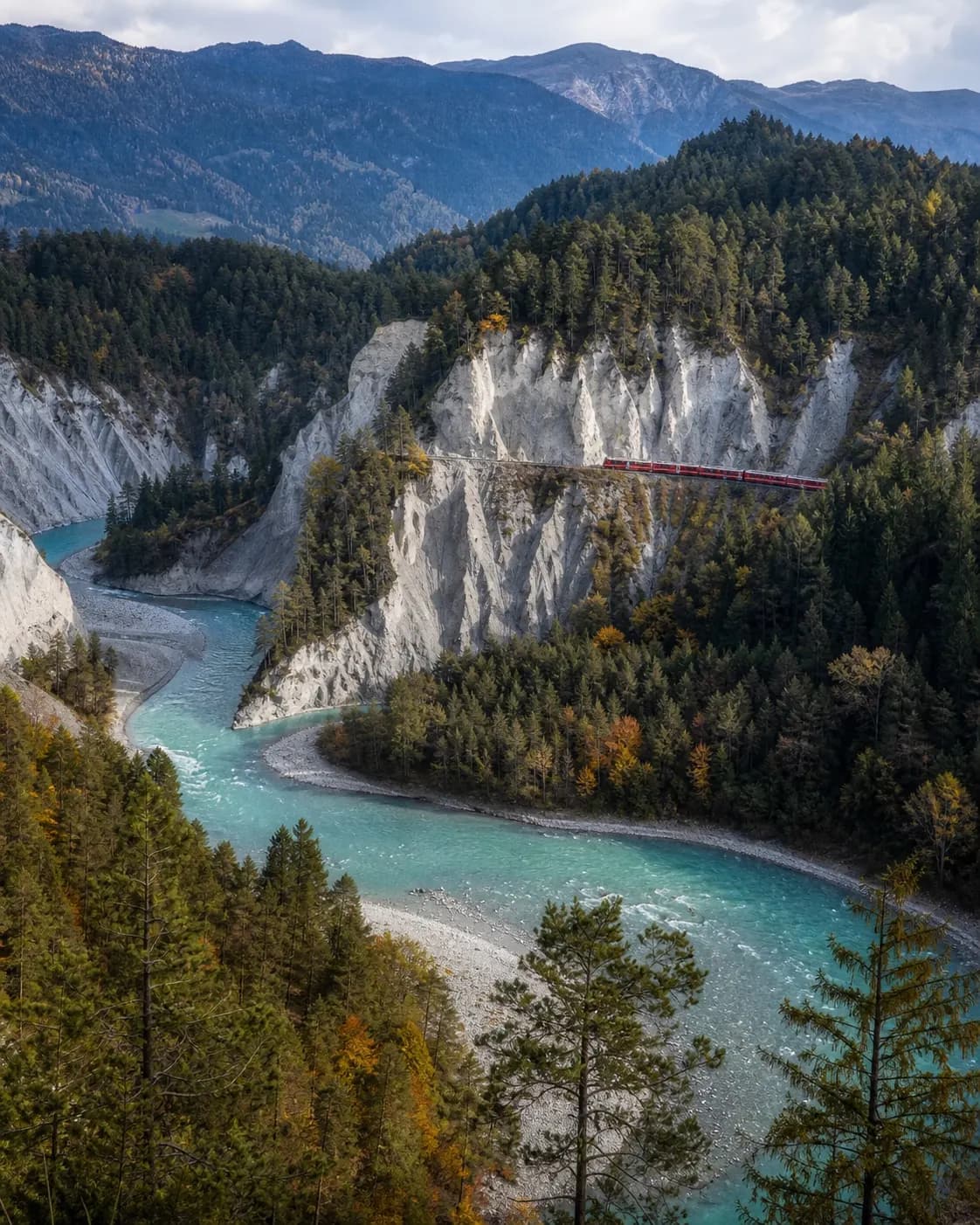 Rheinschlucht Ruinaulta mit rotem Zug und türkisfarbenem Rhein